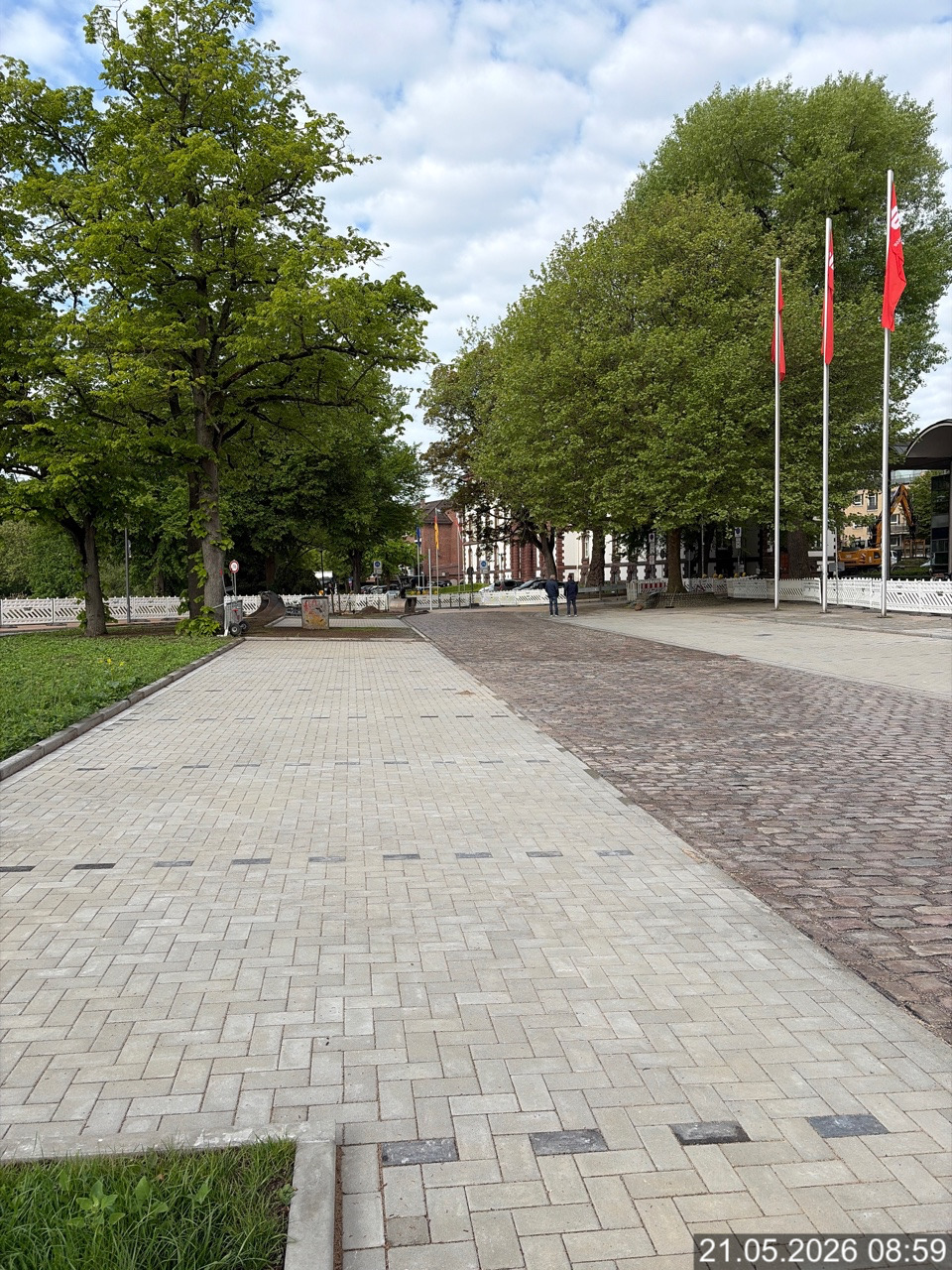 Gepflasterte Platzfläche mit Bäumen und Fahnen an der Förde Sparkasse in Kiel.